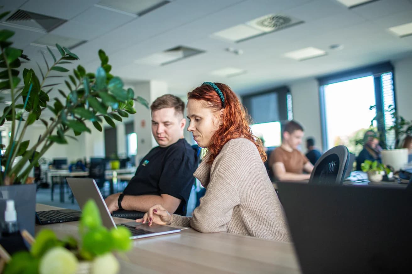 Dwie osoby z zespołu Pragmatic Coders pracujące przy laptopie